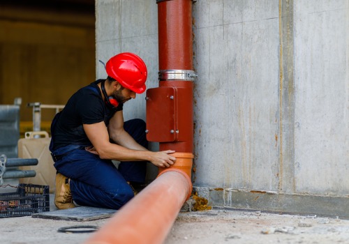 A Commercial Plumber for East Peoria IL inspecting a pipe in the basement of a facility