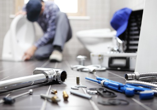 Tools and pipes on the floor as a plumber is looking to replace a toilet during Bathroom Plumbing in East Peoria IL