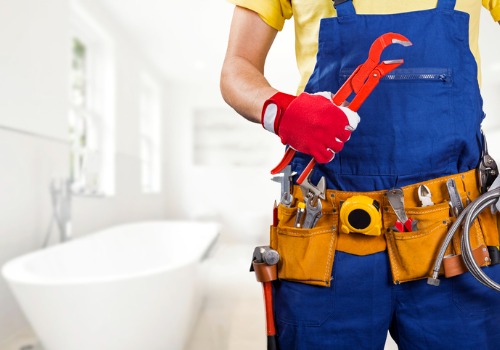 A plumber with a wrench, having finished installing a bathtub