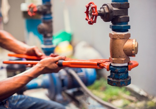 A contractor working on heavy-duty pipes, part of Commercial Plumbing in East Peoria IL